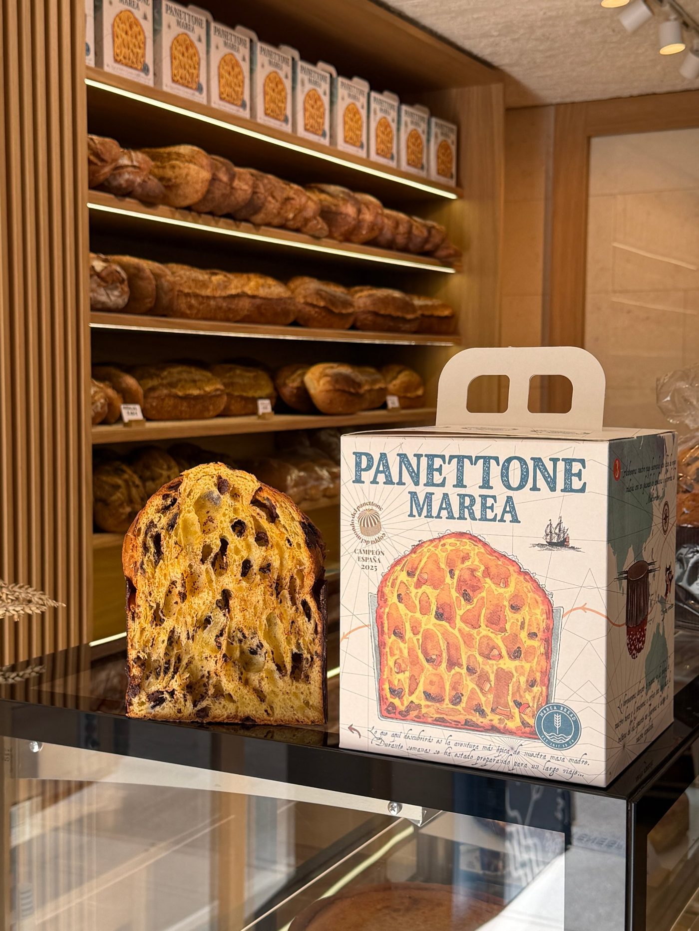 Caja de Panettone Marea junto a un panettone cortado en la tienda